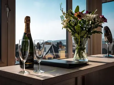 a bottle of champagne and glasses on a table with a window at Mereside in Douglas