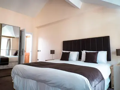 a bedroom with a large bed with a large headboard at Mereside in Douglas