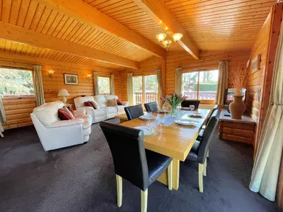 a dining room with a table and chairs at Beautiful Norwegian Lodge in Kippford with Garden - Pass the Keys in Dalbeattie