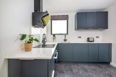 a kitchen with blue cabinets and a white counter top at Snowdrop, Penruddock an Eco and dog friendly lodge with hot tub, 10 minutes to Lake Ullswater in Penruddock