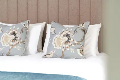 a bed with three pillows on it at Snowdrop, Penruddock an Eco and dog friendly lodge with hot tub, 10 minutes to Lake Ullswater in Penruddock