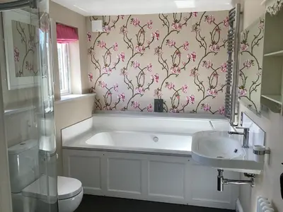 a bathroom with a tub and a toilet and a sink at Porch Cottage, a luxurious characterful cottage within walking distance of Keswick town centre in Keswick