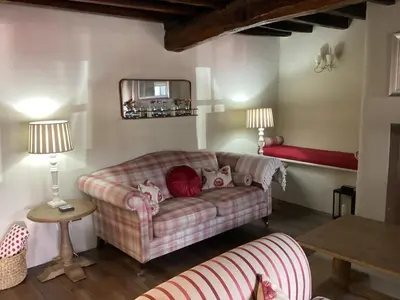 a living room with a couch and a mirror at Porch Cottage, a luxurious characterful cottage within walking distance of Keswick town centre in Keswick