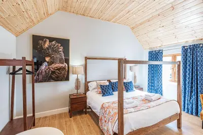 a bedroom with a bed with a wooden ceiling at Kestrel Lodge 2 with Hot Tub in Newton Stewart
