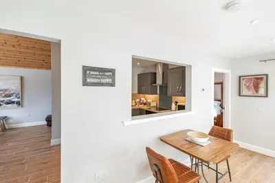 a dining room and living room with a table and chairs at Kestrel Lodge 2 with Hot Tub in Newton Stewart