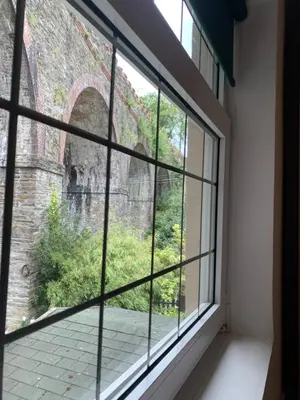 a window in a room with a brick wall at The Apartment, Bridge House in Laxey