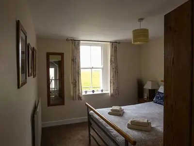 a bedroom with a bed with two towels on it at Gulls Hatch in Maryport
