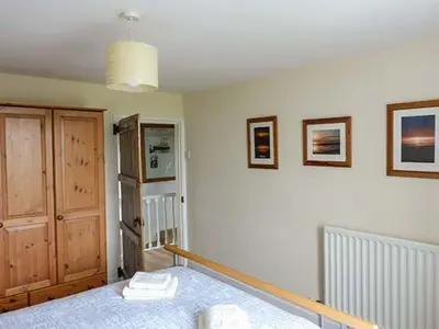 a room with a bed and a wooden door at Gulls Hatch in Maryport