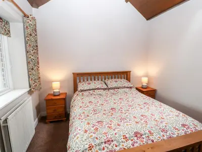 a bedroom with a bed and two lamps on tables at The Flat in Carlisle