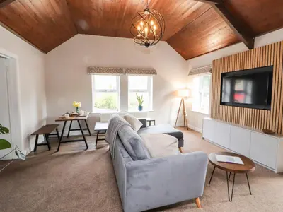 a living room with a couch and a tv at The Flat in Carlisle