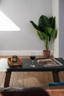 a table with a glass of wine and a plant at Kestrel Lodge 3 with Hot Tub in Newton Stewart