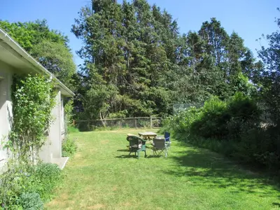 a backyard with a table and chairs in the grass at Glenauld Cottage in Kirkcudbright