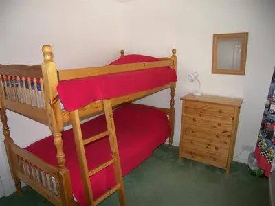 a bedroom with a bunk bed and a dresser at Glenauld Cottage in Kirkcudbright