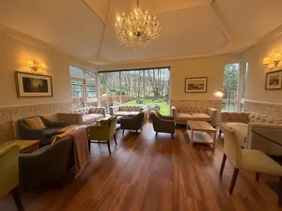 a waiting room with couches and chairs and a chandelier at The Grasmere Hotel in Grasmere