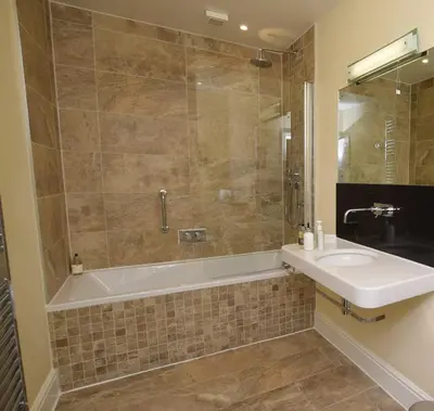 a bathroom with a tub and a sink and a shower at The Grasmere Hotel in Grasmere