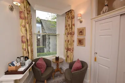 a room with two chairs and a table and a window at The Grasmere Hotel in Grasmere