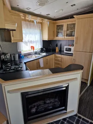 a kitchen with a fireplace in the middle of it at Just Resort No29 in Balminnoch