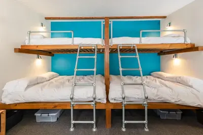 two bunk beds in a room with blue walls at Cosy Glamping In the Eskdale Valley - Studio Lodges and Mega Pods in Eskdale