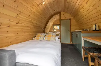 a bedroom in a log cabin with a bed at Cosy Glamping In the Eskdale Valley - Studio Lodges and Mega Pods in Eskdale