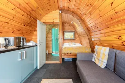 a room with a couch and a bed in a cabin at Cosy Glamping In the Eskdale Valley - Studio Lodges and Mega Pods in Eskdale