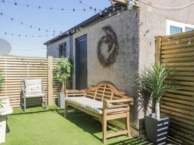 a bench sitting in a yard next to a building at Seaspray in St Bees