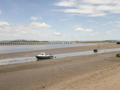 two boats sitting on the sand on the beach at Wainwright Cottage in Seascale