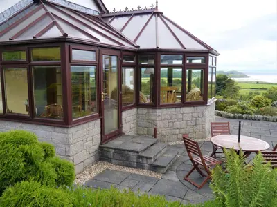 a gazebo with a table and chairs on a patio at Collin Hill House in Castle Douglas