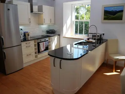 a kitchen with a large island in the middle of it at Rusko Stables in Gatehouse of Fleet