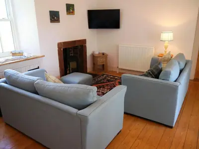 a living room with two couches and a fireplace at Rusko Stables in Gatehouse of Fleet