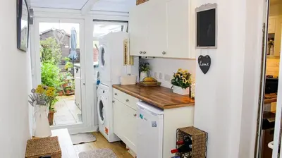 a kitchen with white cabinets and a refrigerator at Spacious Holiday Home in Cumbria in Arlecdon
