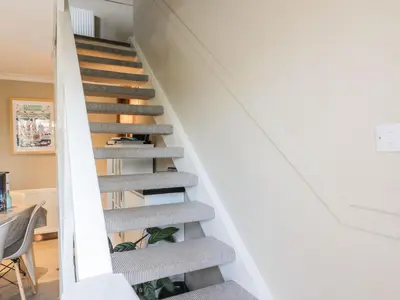 an open stairwell in a home with white walls at Millbrook Cottage in Dalbeattie