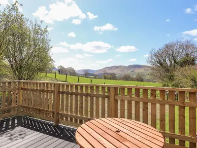 a wooden deck with a wooden table on a fence at Whiteside in Cockermouth