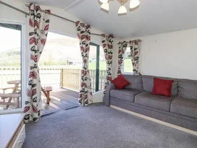 a living room with a couch and a balcony at Swinside in Cockermouth