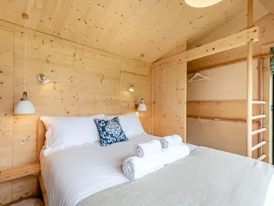 a bedroom with a bed in a wooden cabin at The Curve At Caerlaverock Estate in Glencaple