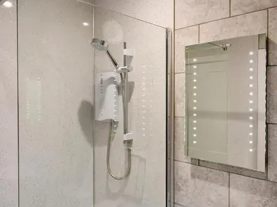 a shower in a bathroom with a glass door at Brow Riding in Keswick