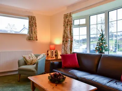 a living room with a couch and a christmas tree at Brow Riding in Keswick