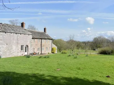 an old brick building in a grassy field at Rushgill House in Sebergham