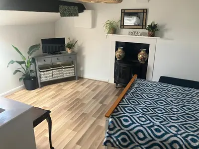 a living room with a bed and a fireplace at Bells yard Cottage Maryport in Maryport