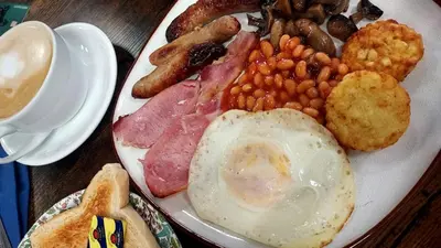 a plate of breakfast food with eggs beans and bacon at Bells yard Cottage Maryport in Maryport