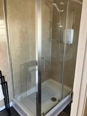a shower with a glass door in a bathroom at Bells yard Cottage Maryport in Maryport