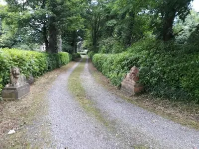 a gravel road with bushes and trees on either side at Eta's Manor @ Brooklands in Maryport