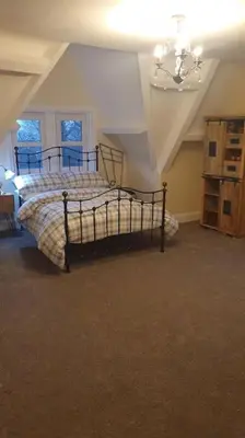 a bedroom with a bed and a chandelier at Eta's Manor @ Brooklands in Maryport