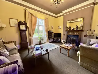 a living room with a couch and a table at Calthwaite Hall Bed & Breakfast in Penrith