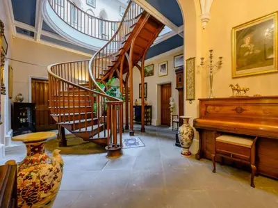 a large room with a staircase and a piano at Calthwaite Hall Bed & Breakfast in Penrith